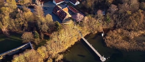 An aerial view of a residential area with a large house, a dock, and a small body of water.