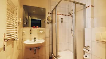 Ein Badezimmer mit Waschbecken, Spiegel, Dusche und Toilette.