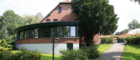 A brick building with a green roof and a covered walkway.