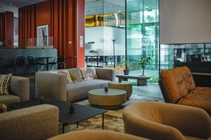 Een moderne lounge met banken, een bijzettafeltje en een zithoek met stoelen.