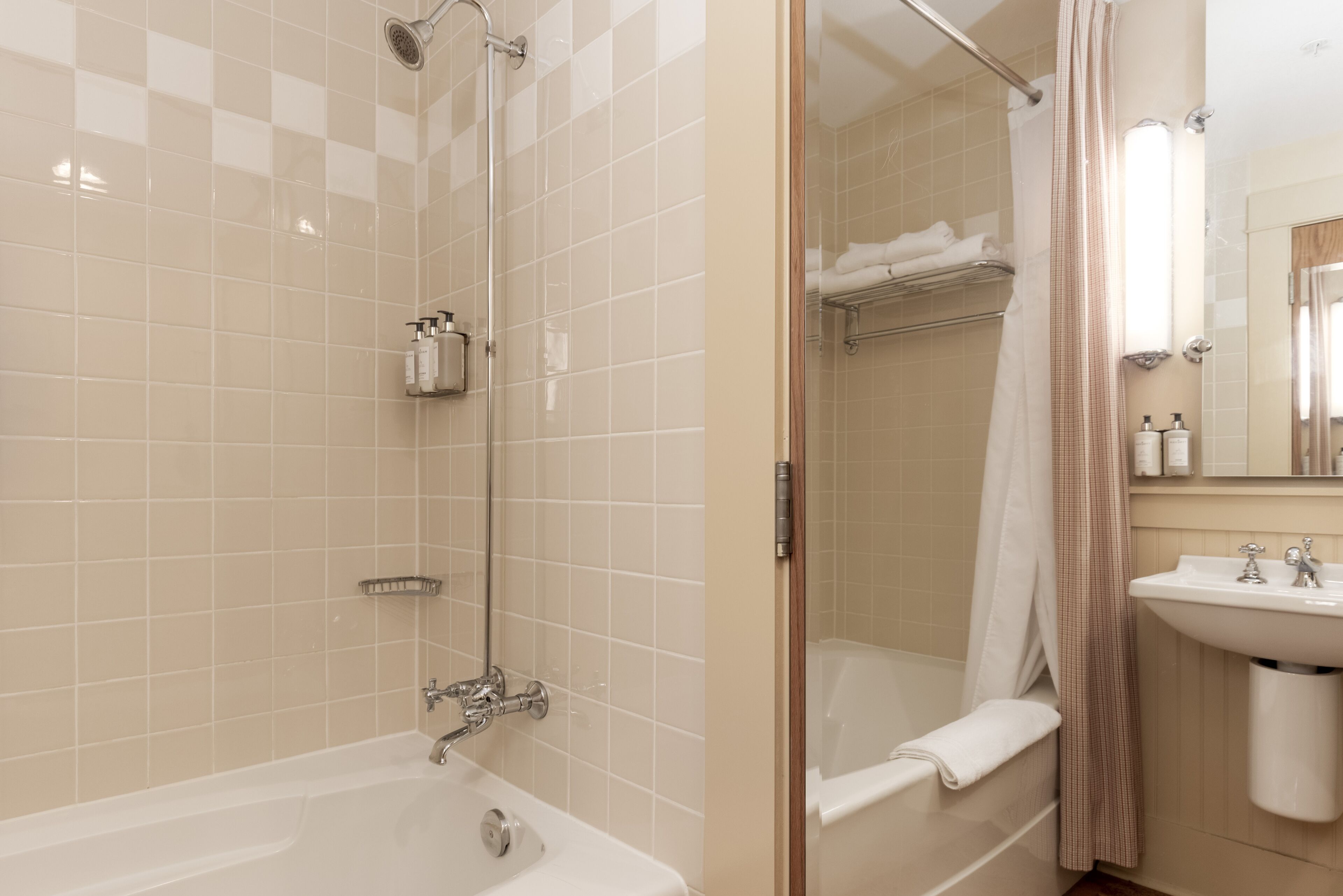 A modern bathroom with a bathtub, shower, and sink.