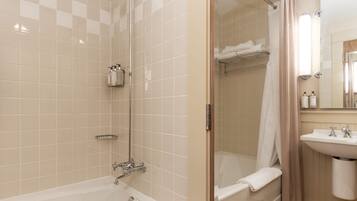 A modern bathroom with a bathtub, shower, and sink.