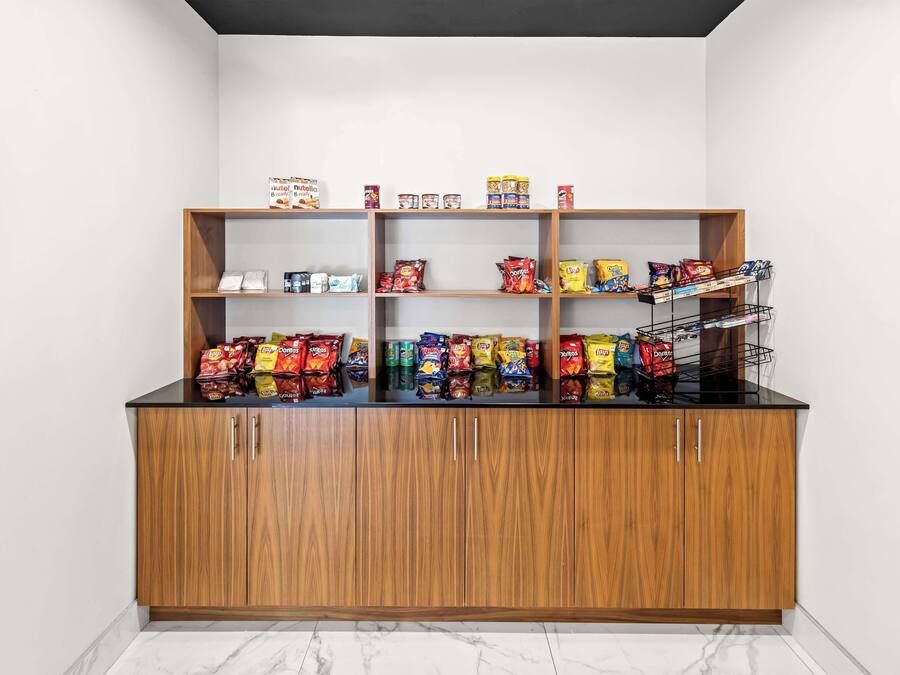 Un bar servant des collations, avec des meubles et des étagères en bois remplis de diverses collations et boissons.