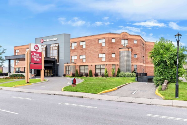 A Best Western PLUS hotel with a brick facade, large windows, and a well-maintained lawn. - Best Western Plus Montreal East (Montreal)