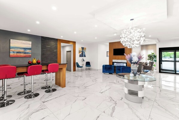 A modern interior with a bar area, seating, and a glass-top table.