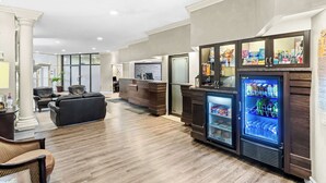 A lobby with a reception desk, seating area, and a beverage refrigerator.