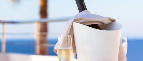 Une table avec une bouteille de champagne, un verre et des bols remplis de collations.