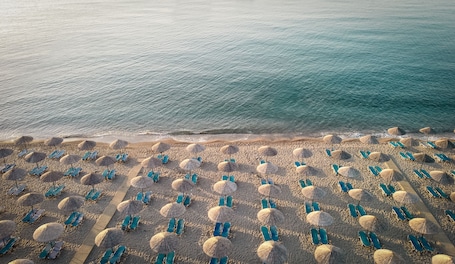 Liegestühle, Sonnenschirme, Strandtücher, Massagen am Strand. Mitsis Rodos Maris