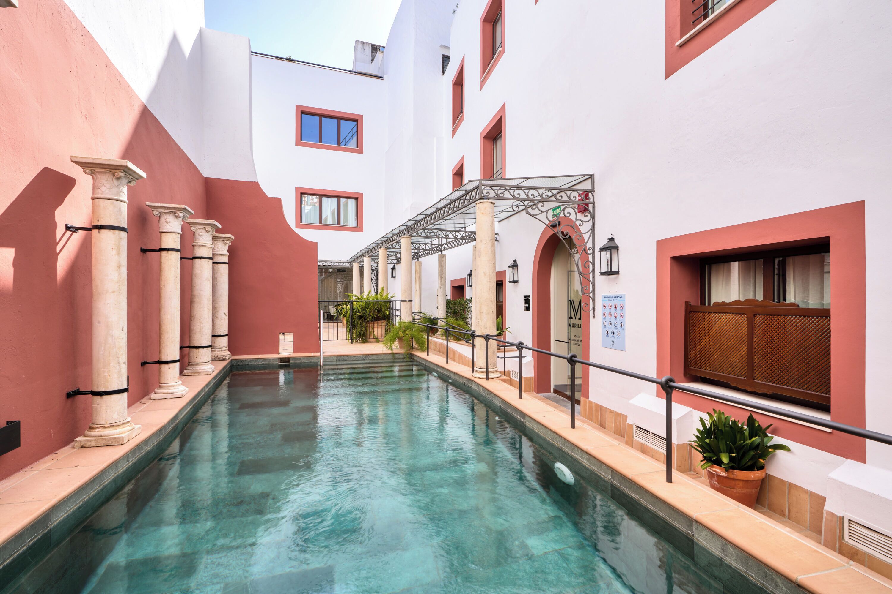 Een buitenzwembad, ligstoelen bij het zwembad