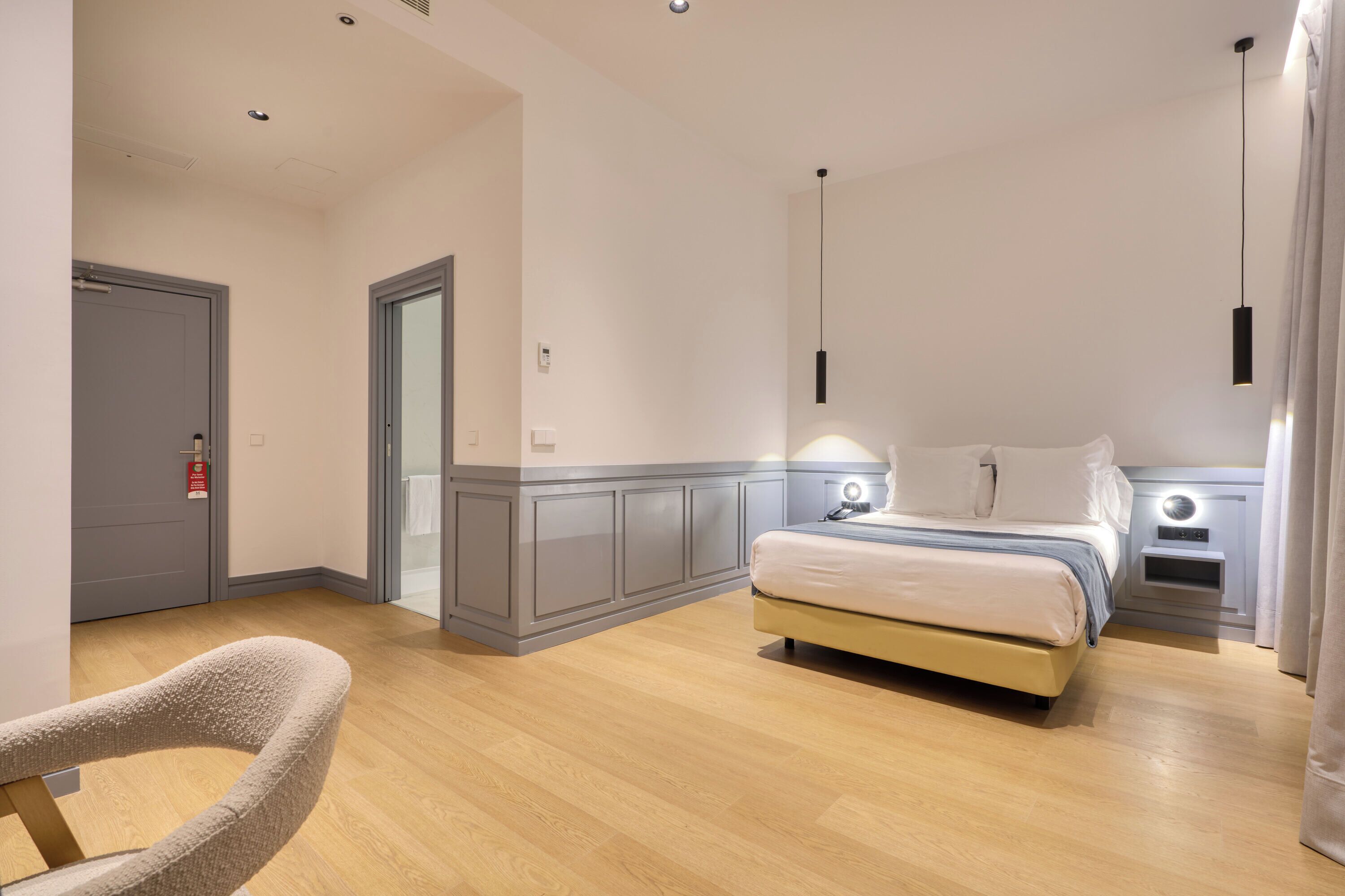 Une chambre à coucher moderne avec un lit, des tables de chevet et une chaise.