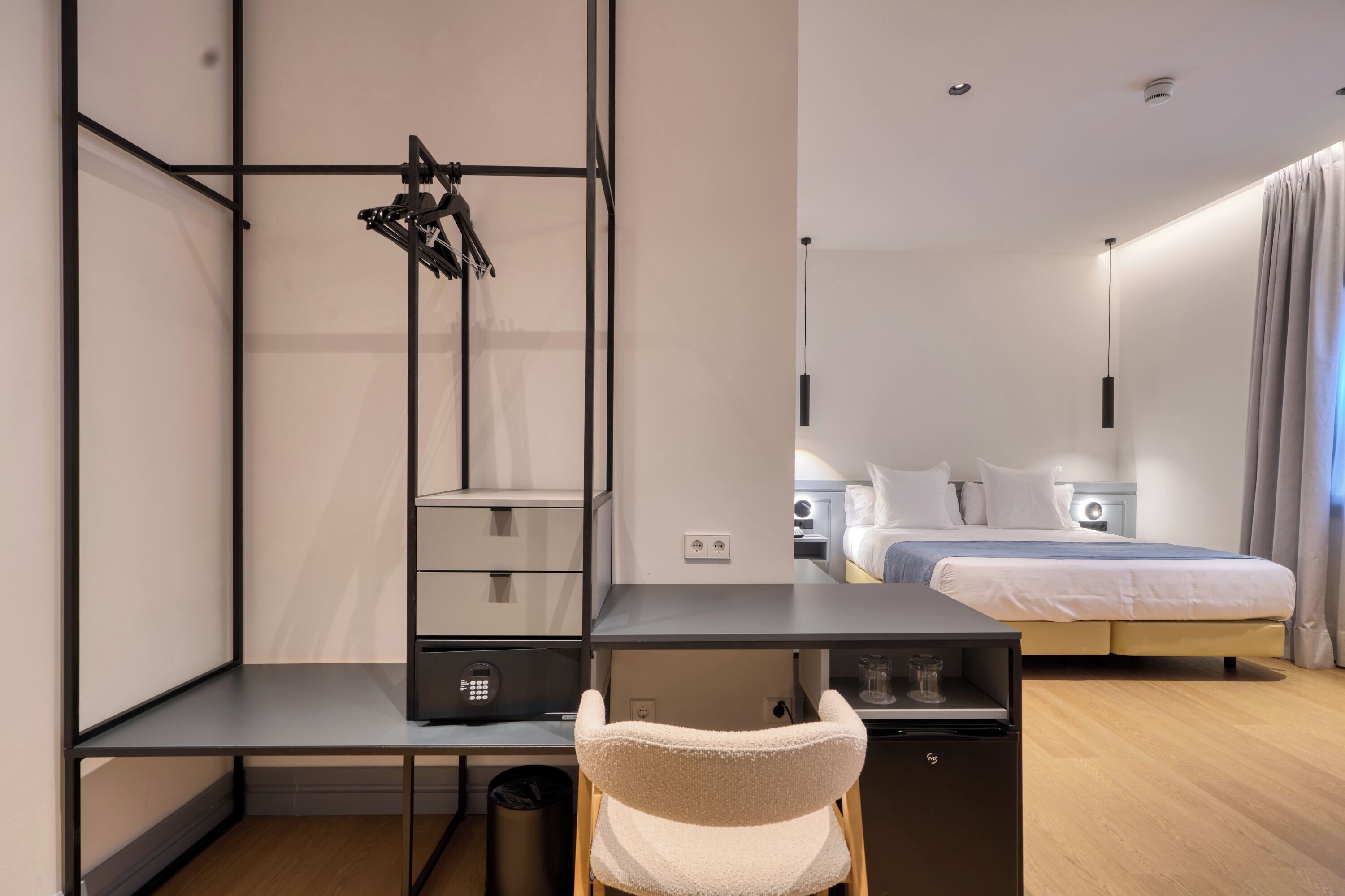 Una habitación de hotel moderna con escritorio, silla y cama con cabecera.