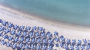 Playa privada, arena blanca, sillas reclinables de playa, sombrillas