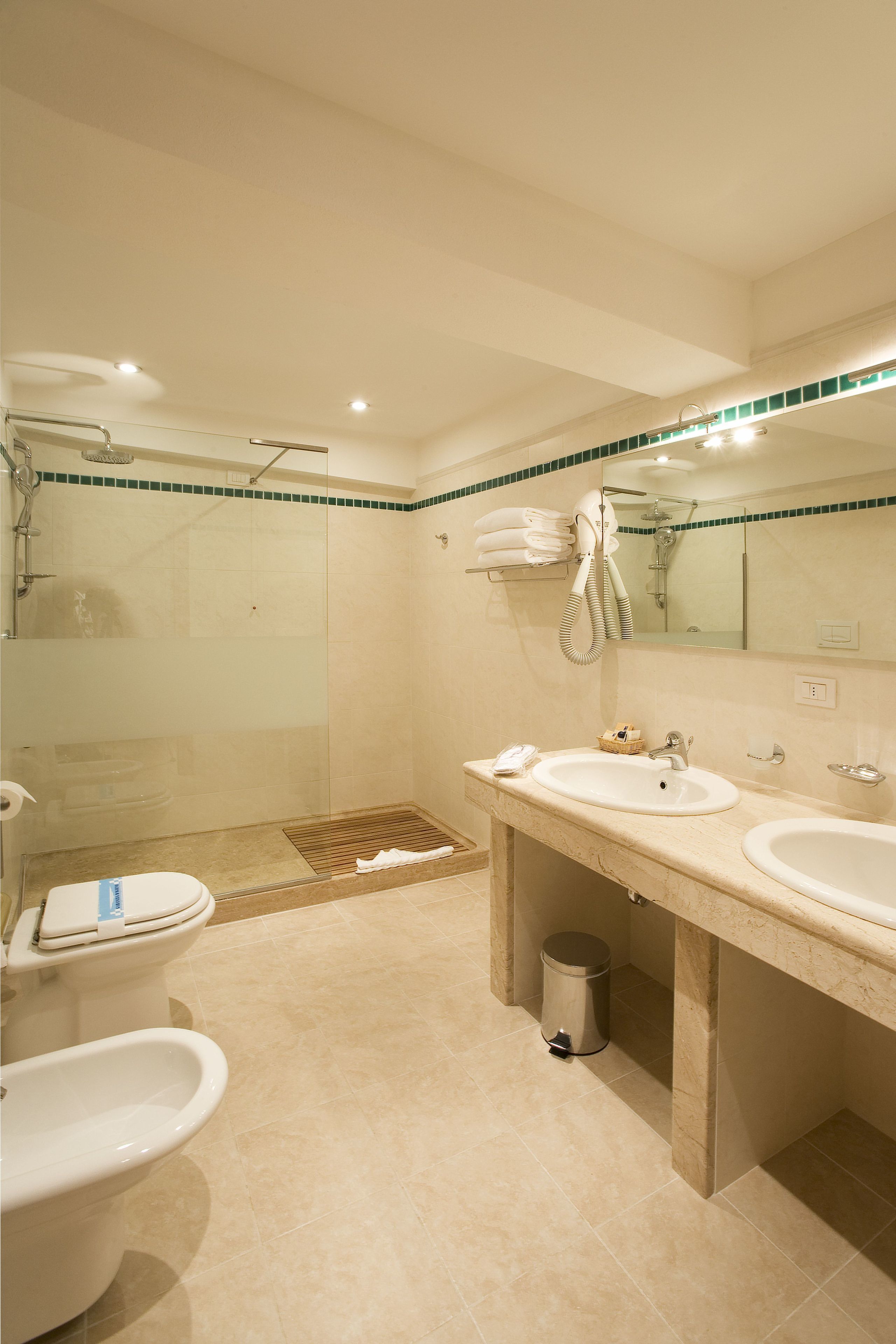 Une salle de bain moderne avec deux lavabos, une douche et des toilettes.