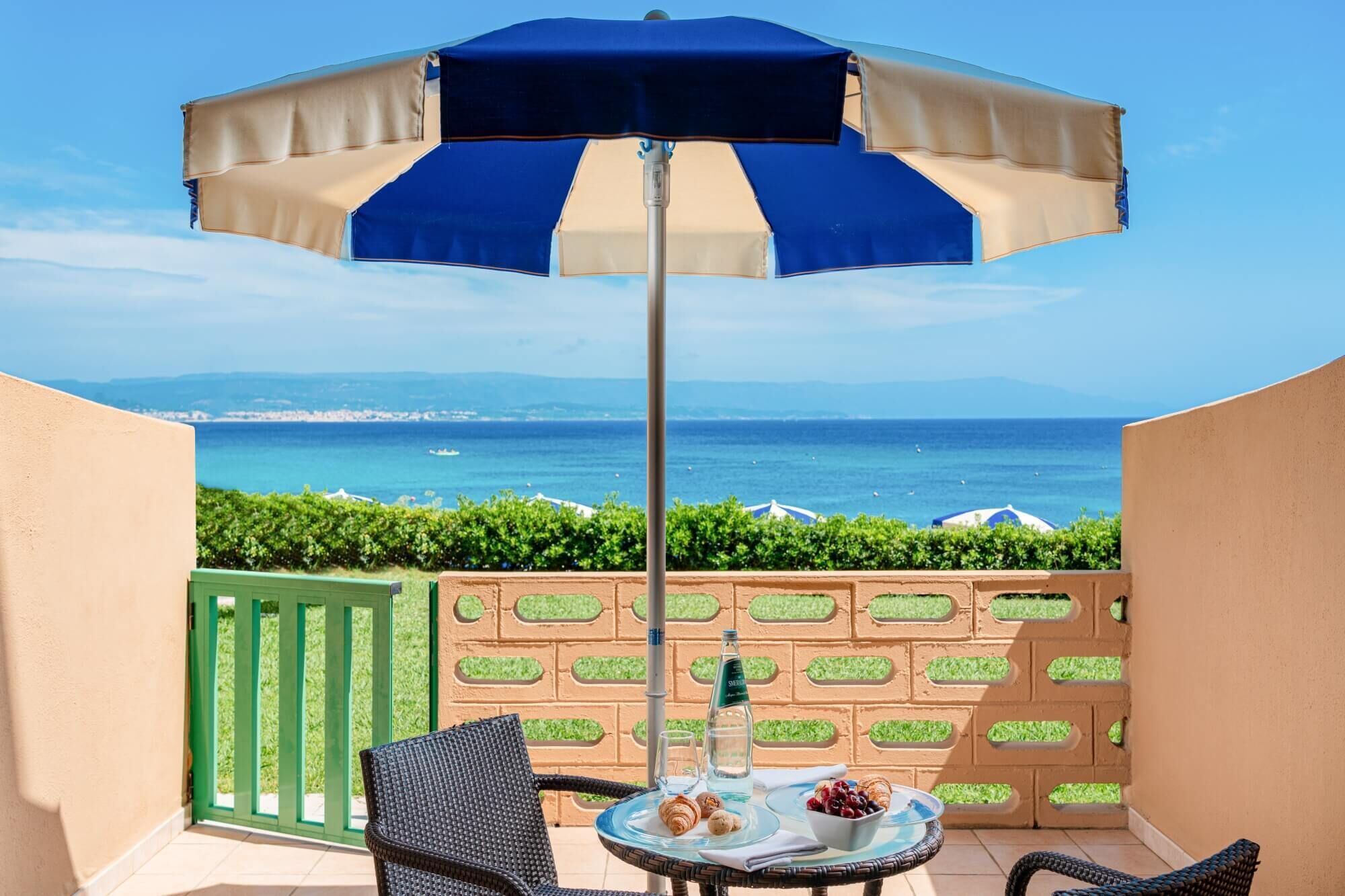 A balcony with a table, chairs, and a bottle of water.