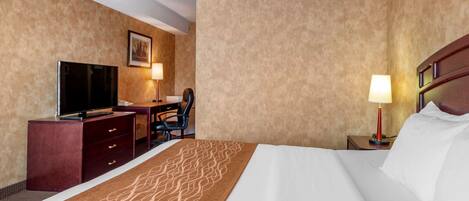 A hotel room with a bed, a desk, a television, and a chair.