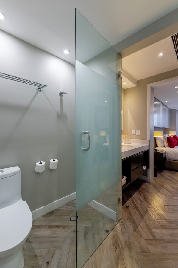 Une salle de bain moderne avec une douche à parois de verre, des toilettes et un lavabo.