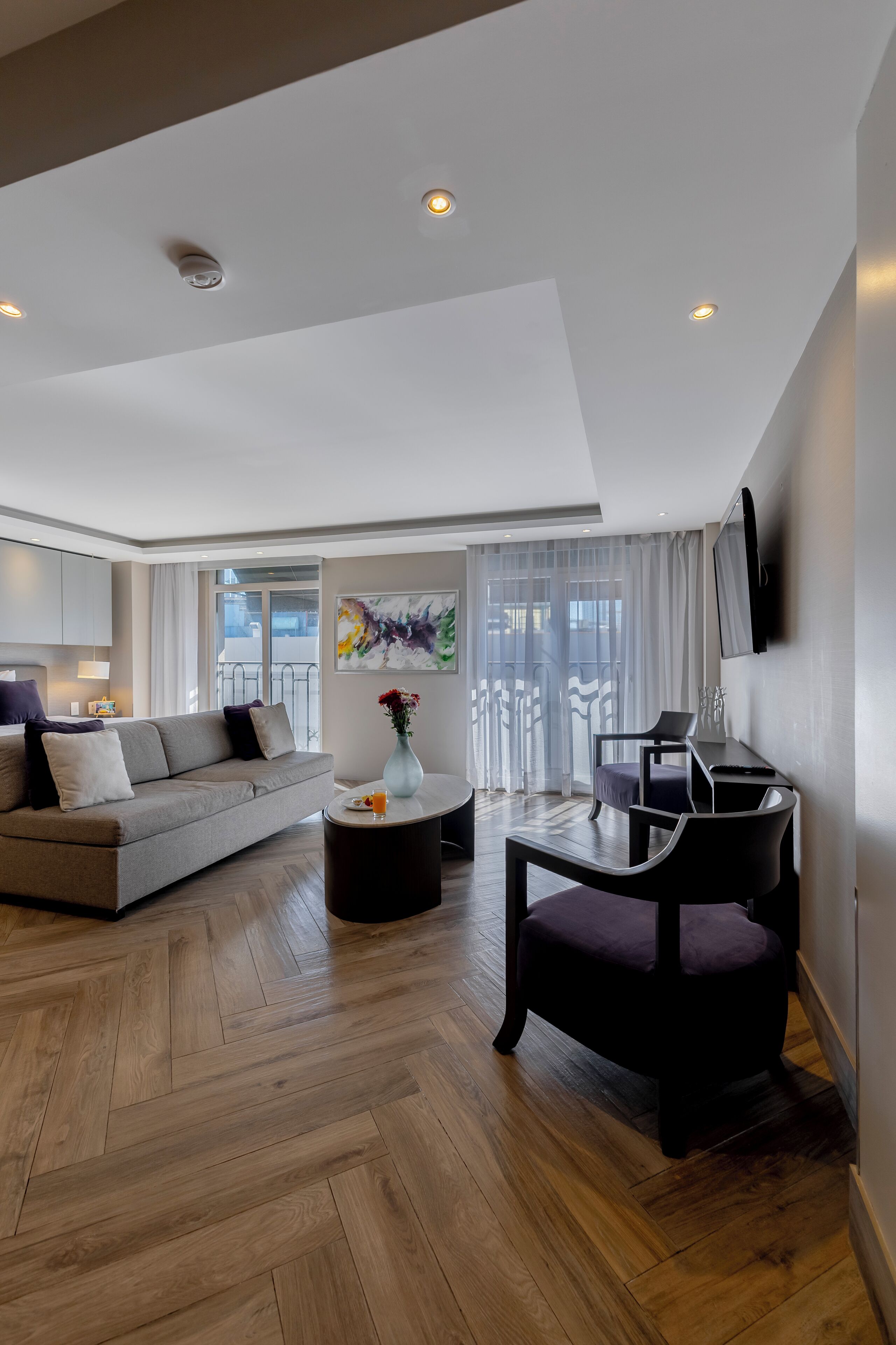 A modern living room with a sofa, coffee table, and a dining area with a chair and table.