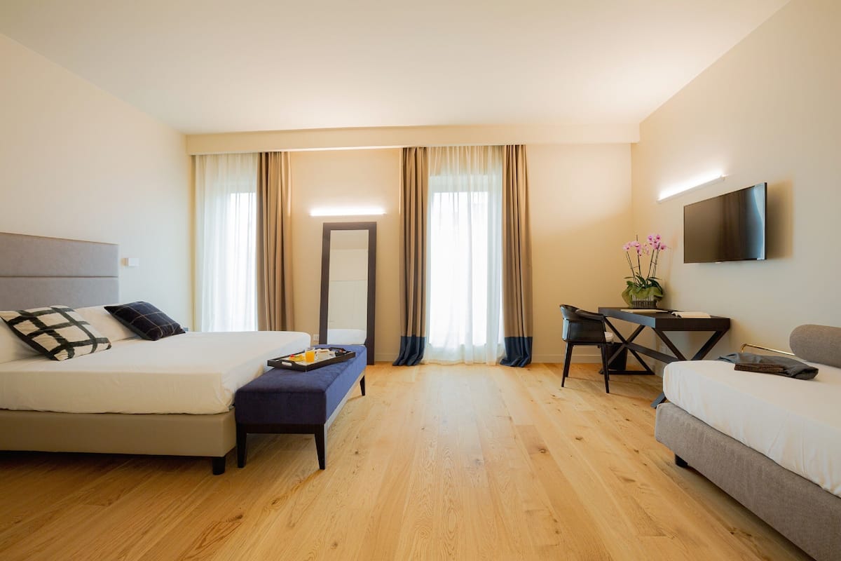 Una habitación de hotel con una cama, un escritorio, una silla y un televisor.