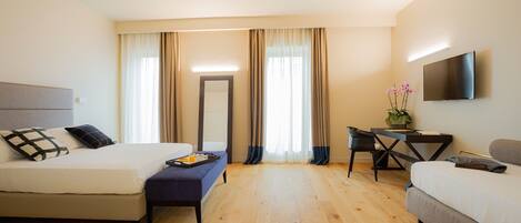 A hotel room with a bed, a desk, a chair, and a TV.
