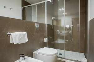 Un bagno moderno con doccia vetrata, un water bianco e un lavabo con specchio.