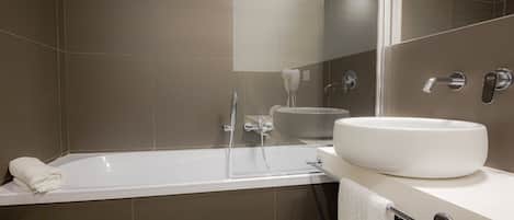 Een moderne badkamer met een bad, een wastafel en een spiegel.