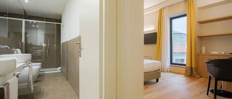 A modern bathroom with a glass shower enclosure, a sink, and a toilet.