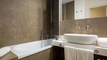 A modern bathroom with a bathtub, a sink, and a glass shower enclosure.