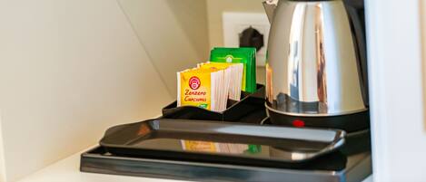 A kitchen area with a kettle, a tray, and packets of tea.