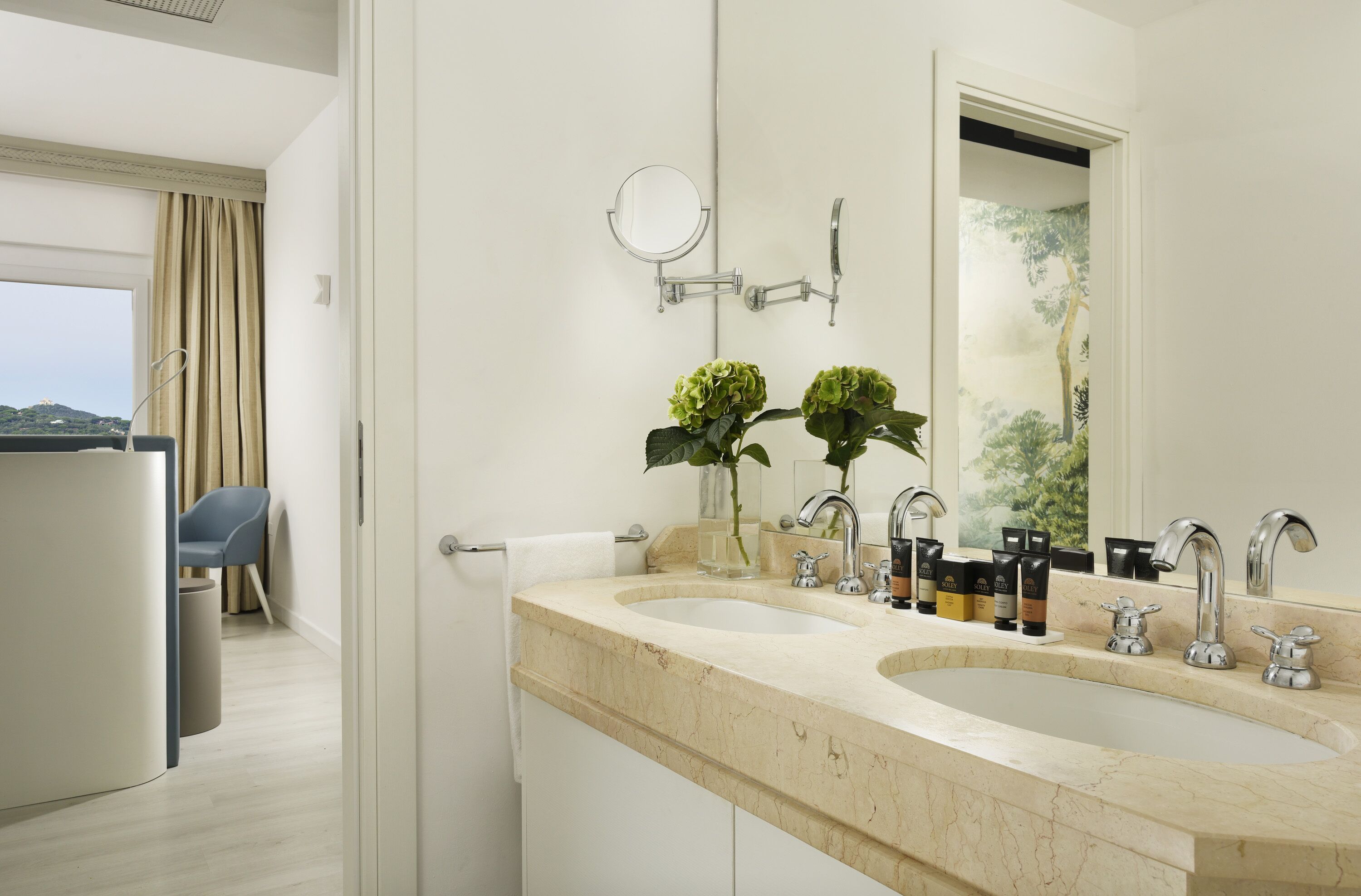 A modern bathroom with two sinks, a mirror, and a view of a balcony.