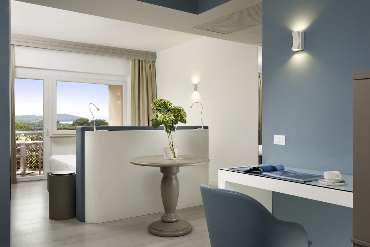 Habitación moderna con una mesa redonda, una silla, una planta pequeña en maceta y vistas al exterior.