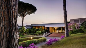 Un edificio moderno con un jardín bien cuidado, que incluye un sendero y plantas con flores.