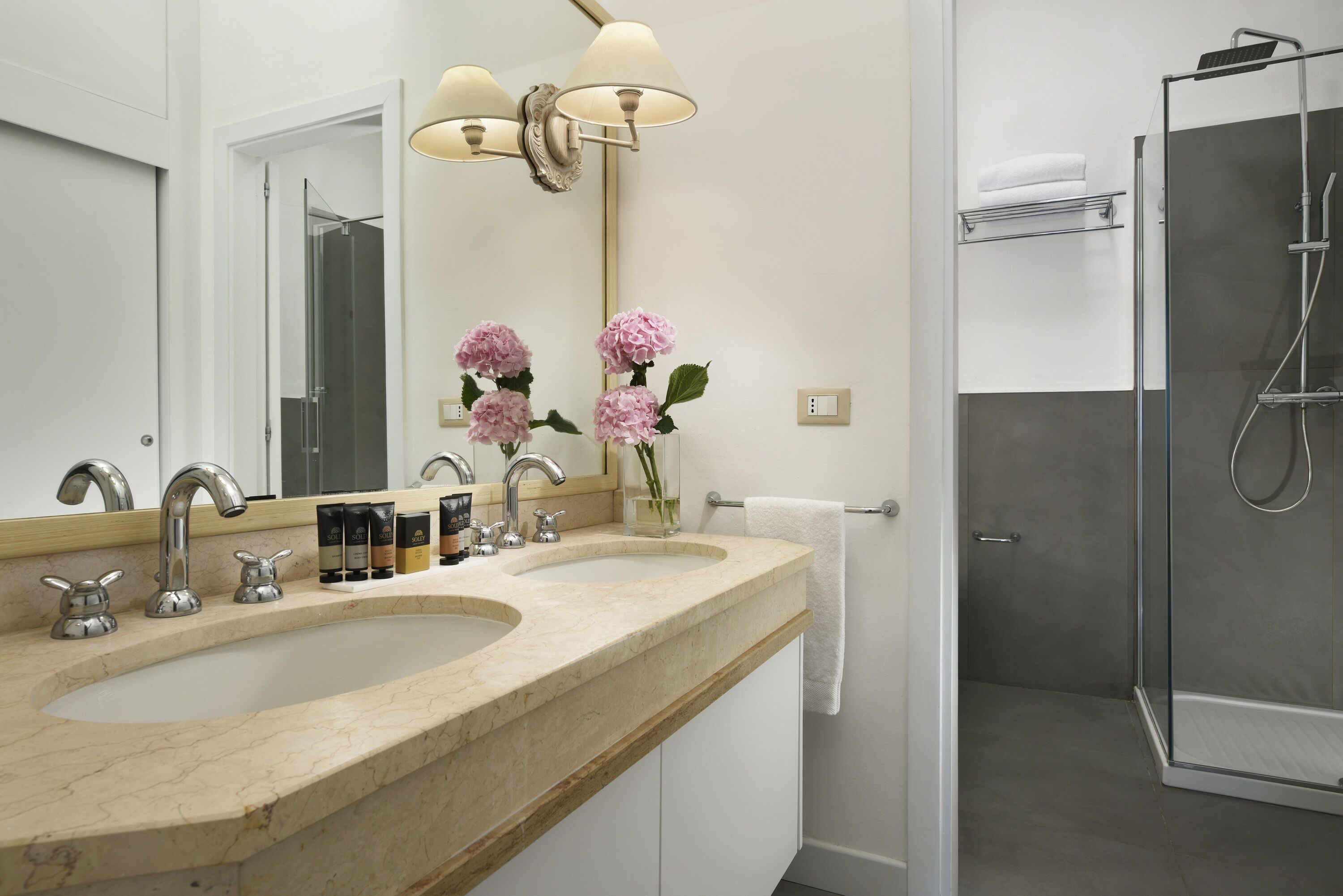 Un bagno con due lavandini, uno specchio e una doccia.