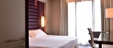Ein Hotelzimmer mit Bett, Schreibtisch und Stuhl.
