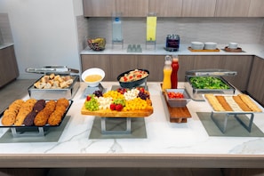 A buffet setup with various food items and beverages.