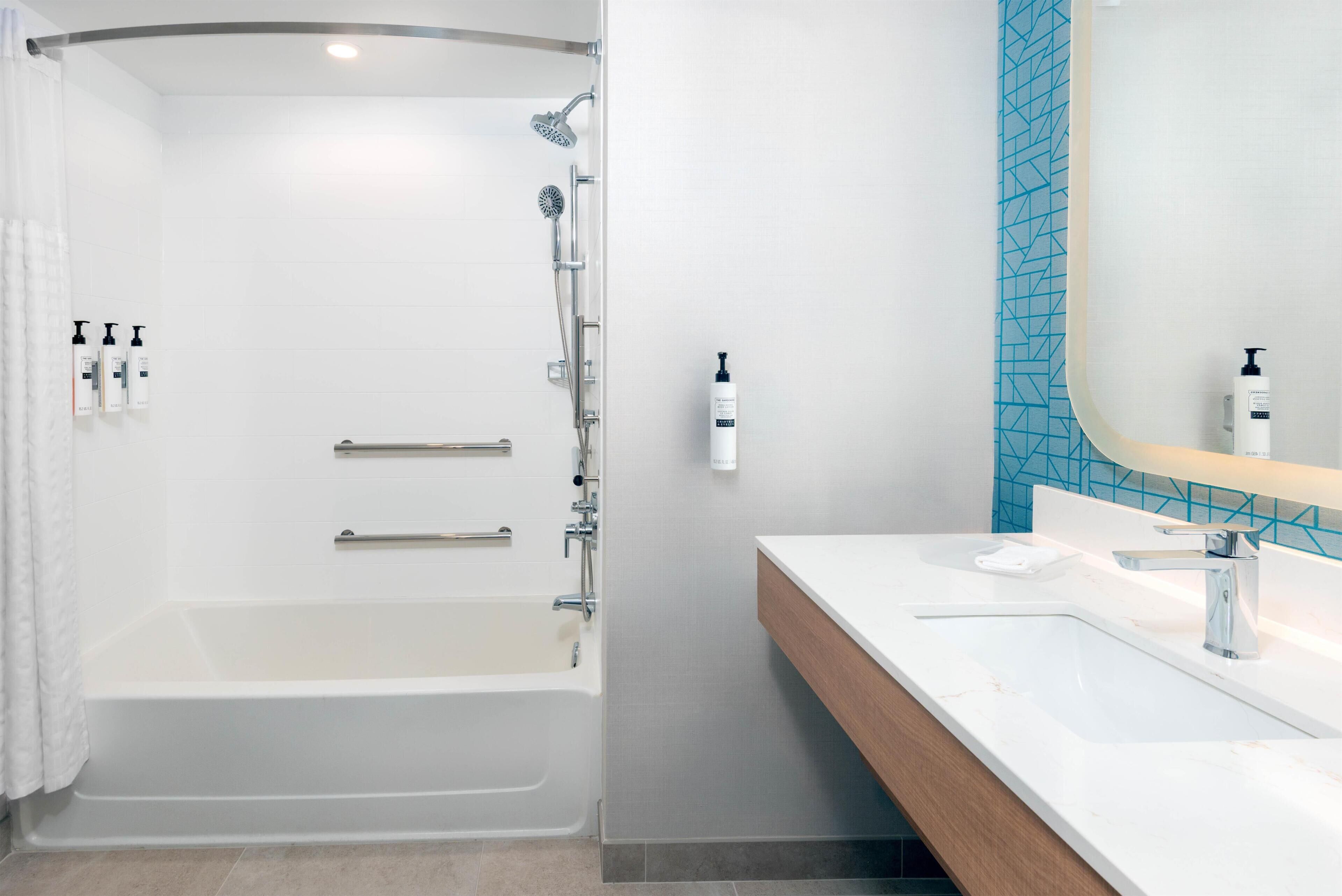 A modern bathroom with a walk-in shower, a bathtub, and a vanity with a mirror.