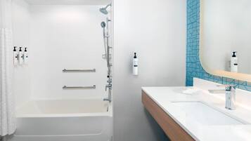 A modern bathroom with a walk-in shower, a bathtub, and a vanity with a mirror.