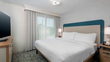 A hotel room with a bed, a television, a desk, and a nightstand.