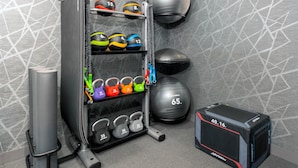 A gym with various exercise equipment including kettlebells, medicine balls, and a squat rack. - Homewood Suites by Hilton Holyoke-Springfield/North (Holyoke)