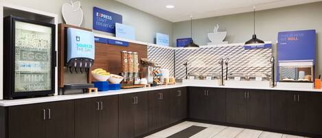 A modern breakfast bar with a variety of food options, including yogurt, eggs, milk, cereal, and hot food.