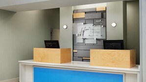 A reception desk with a modern design, featuring a blue accent panel and a wall-mounted sign that reads "Holiday Inn Express & Suites". - Holiday Inn Express Hotel & Suites Panama City-Tyndall by IHG (Panama City)