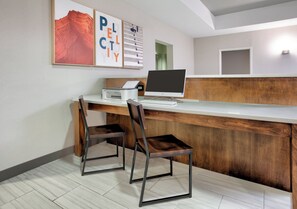 A reception desk with a computer, two chairs, and framed artwork on the wall. - Holiday Inn Express Hotel & Suites Pell City by IHG (Pell City)