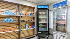 Una presentación de bocadillos con varias marcas, un enfriador de bebidas y un refrigerador.