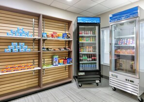 A snack display with various brands, a beverage cooler, and a refrigerated display. - Holiday Inn Express Hotel & Suites Pell City by IHG (Pell City)