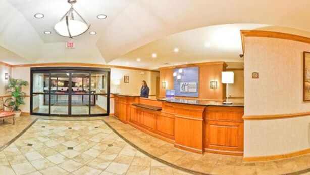 A hotel lobby with a reception desk, a glass door entrance, and a tiled floor. - Holiday Inn Express Forest City by IHG (Forest City)