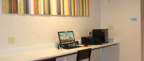 A workspace with a desk, two chairs, a computer, and a monitor.