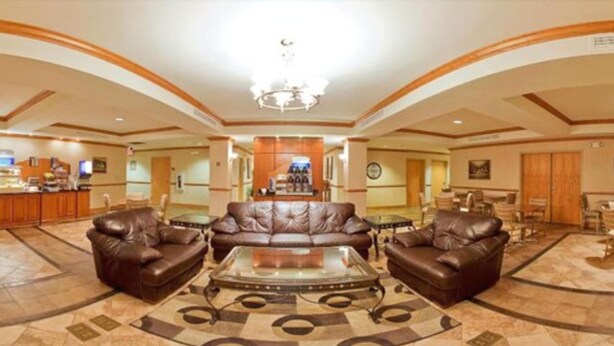 A spacious lobby with leather sofas, a central coffee table, and a chandelier. - Holiday Inn Express Forest City by IHG (Forest City)