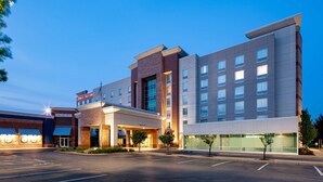 A hotel with a modern design, featuring a large entrance, multiple floors, and a parking lot. - Hampton Inn & Suites St. Louis at Forest Park (St. Louis)