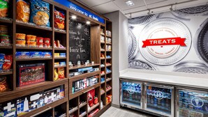 A snack and treat display with various products, including chips and beverages, in a store setting. - Hampton Inn & Suites St. Louis at Forest Park (St. Louis)
