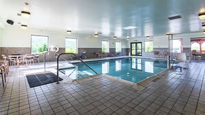 A swimming pool area with tiled flooring, lounge chairs, and a sunroof. - Hampton Inn Pine Grove (Pine Grove)