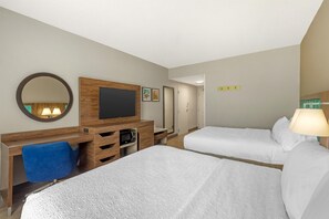 A hotel room with two beds, a desk with a chair, a television, a mirror, and a door. - Hampton Inn Pine Grove (Pine Grove)